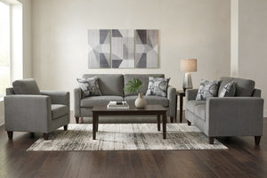 Juego de sala contemporáneo con sofá, loveseat y silla de acento en tela gris. Incluye mesa de centro de madera oscura, cojines decorativos, lámpara lateral, alfombra de área y arte geométrico en tonos neutros.