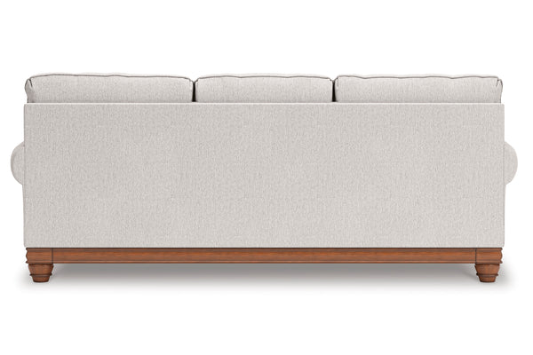 Sofá gris claro con patas de madera sobre fondo blanco.