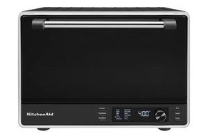 Horno/tostadora de sobremesa KitchenAid en color negro y plateado, con una gran puerta de cristal negro con tirador plateado, un panel de control digital con pantalla que muestra 400 grados y un selector giratorio en la parte frontal.