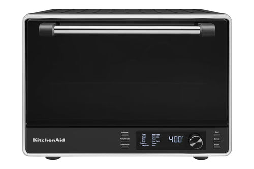 Horno/tostadora de sobremesa KitchenAid en color negro y plateado, con una gran puerta de cristal negro con tirador plateado, un panel de control digital con pantalla que muestra 400 grados y un selector giratorio en la parte frontal.