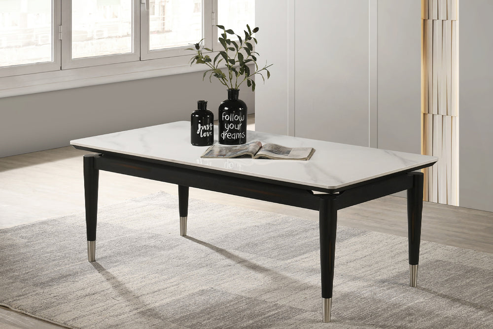 Mesa de centro rectangular con patrón de mármol blanco con objetos decorativos en un ambiente de sala. 