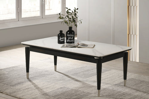 Mesa de centro rectangular con patrón de mármol blanco con objetos decorativos en un ambiente de sala. 