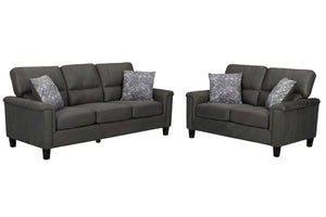 Un sofá y un loveseat a juego, tapizados en tela gris oscuro, cada uno con dos cojines decorativos estampados en gris, se muestran sobre un fondo blanco liso.
