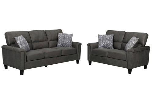 Un sofá y un loveseat a juego, tapizados en tela gris oscuro, cada uno con dos cojines decorativos estampados en gris, se muestran sobre un fondo blanco liso.