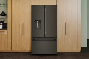 Una nevera de doble puerta de color gris oscuro con un cajón congelador en la parte inferior, contrasta con los armarios de cocina de madera clara.
