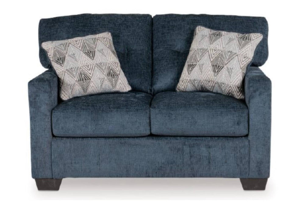 Loveseat azul oscuro con dos cojines decorativos sobre un fondo blanco. 