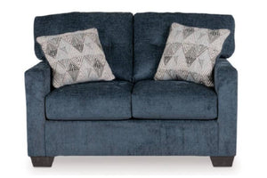 Loveseat azul oscuro con dos cojines decorativos sobre un fondo blanco. 