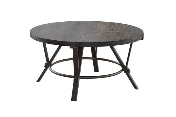 Mesa de centro redonda con tope de madera negra y base de hierro color gris sobre fondo blanco.