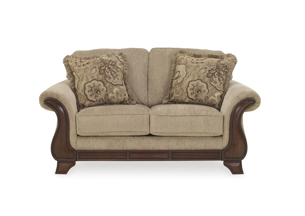 Loveseat beige con cojines decorativos sobre fondo blanco.