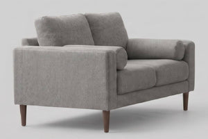 Moderno loveseat de tela gris claro texturizada con patas cónicas de madera marrón oscura, vista en ángulo de tres cuartos sobre fondo neutro.