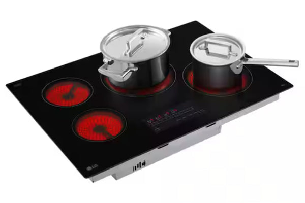Tope de estufa negra de marca LG con cuatro quemadores y dos ollas encima de dos quemadores sobre un fondo blanco. 