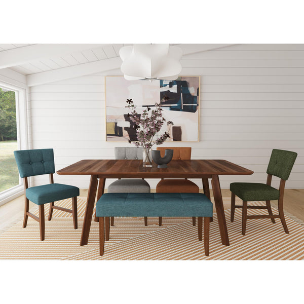 Mid-century walnut dining table with teal, gray, green, and orange upholstered chairs and teal bench on striped rug.