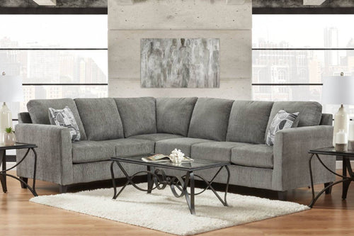 Sofá modular gris en una sala de estar con una mesa de centro y elementos decorativos.