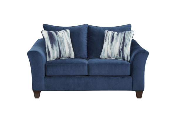 Loveseat de color azul marino con cojines decorativos sobre un fondo blanco. 