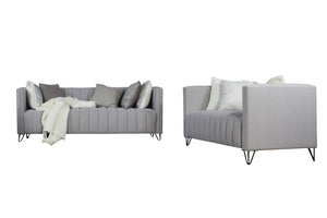 Sofá y loveseat de color gris claro con cojines decorativos sobre un fondo blanco. 