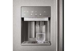 Un dispensador de agua de acero inoxidable en la puerta de un refrigerador, con un vaso de vidrio colocado debajo del grifo y el agua fluyendo hacia él.