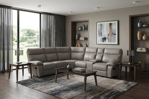 Sala moderna con sofá seccional reclinable en color gris, consola central con portavasos y mesas auxiliares de madera. Ambientada con alfombra decorativa, lámparas y estanterías empotradas en tonos neutros.