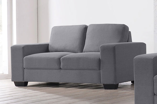Loveseat de color gris en una sala neutral. 