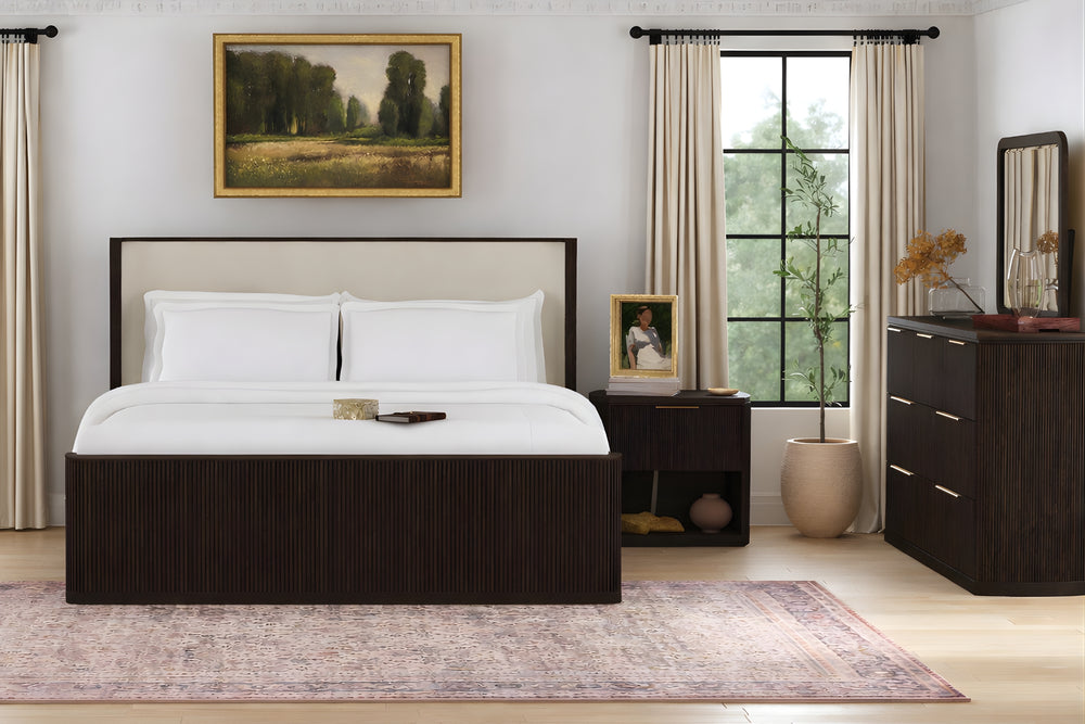 Habitación moderna con una cama, un gavetero con espejo y una mesa de noche. 