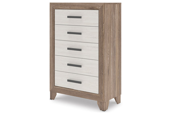 Un chest de 5 cajones con estructura en tono madera clara y frentes de cajón blancos, con tiradores horizontales en gris oscuro, presentado sobre un fondo blanco uniforme.