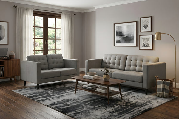 Sala moderna con sofá y loveseat grises de estilo contemporáneo, mesa de centro de madera, alfombra estampada y decoración minimalista. El espacio incluye lámpara de pie, arte de pared y ventana con luz natural.