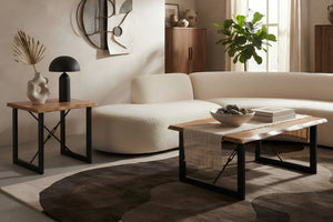 Una escena de una sala de estar moderna con un sofá seccional de bouclé color crema, una mesa de centro de madera con estructura de metal negro, una mesa auxiliar a juego y una alfombra abstracta de color marrón oscuro.