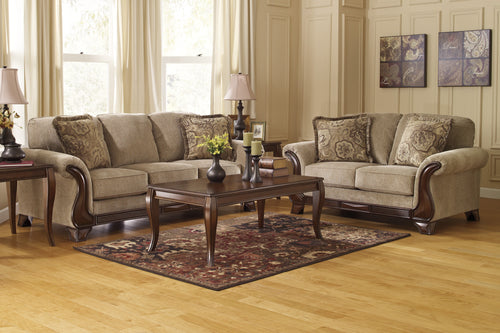 Salón con sofás y lovesear color beige, mesa de centro de madera y elementos decorativos.