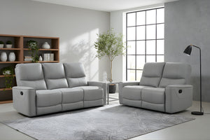 Sofá y loveseat reclinable de color gris en una sala moderna con objetos decorativos. 