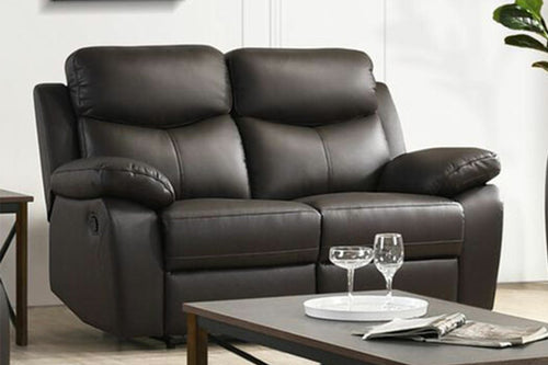 Loveseat reclinable de tres asientos color marrón oscuro de apariencia piel, con respaldos altos acolchados, brazos anchos tipo almohada, costuras visibles y botón lateral de reclinación sobre un fondo blanco.