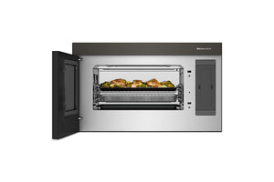 Un horno microondas empotrable con la puerta abierta, que deja ver la puerta de cristal, las rejillas interiores y las bandejas para alimentos. El electrodoméstico tiene un exterior de acero inoxidable con paneles gris oscuro y un pequeño logotipo de Miele visible en la parte superior derecha.