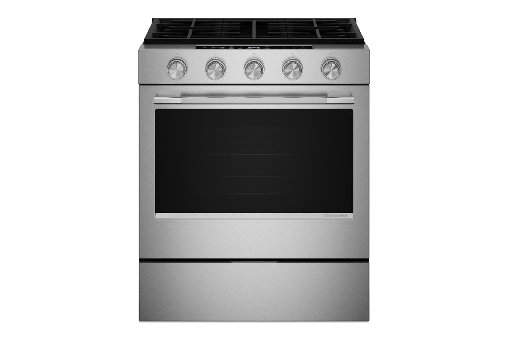 Una estufa de gas independiente de acero inoxidable con cinco perillas de control, una puerta de horno de vidrio negro y una gaveta inferior, mostrada sobre un fondo blanco liso.