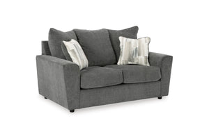 Loveseat gris con cojines decorativos sobre fondo blanco.