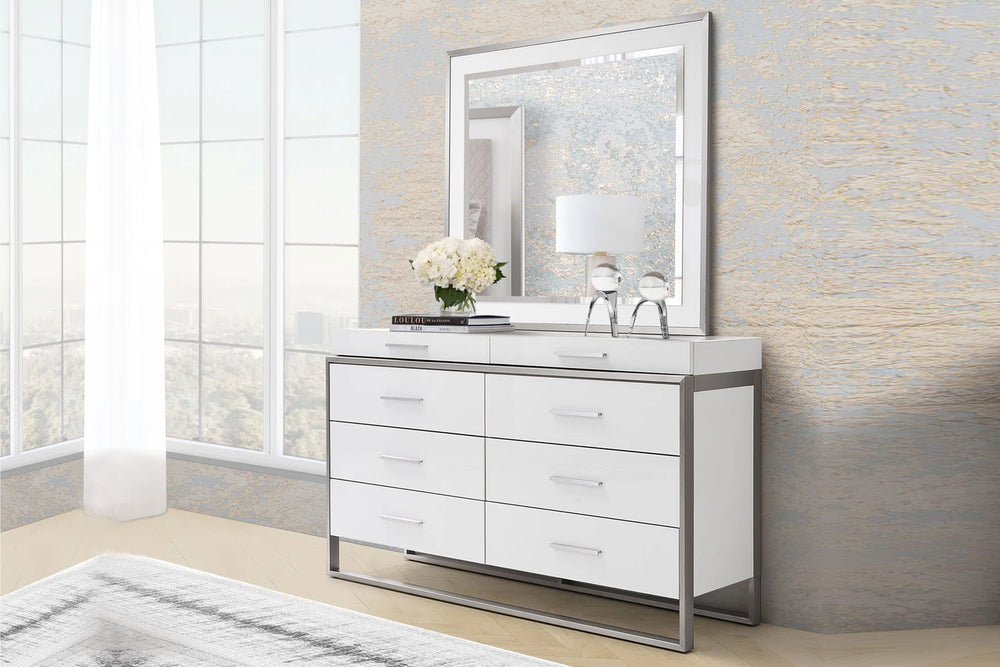 Gavetero blanco y plateado con espejo de ocho gavetas sobre fondo blanco.
