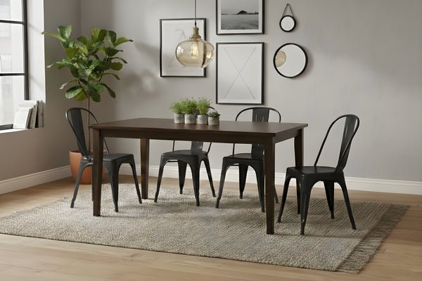 Mesa rectangular de madera marrón oscuro con cuatro sillas negras en un ambiente de sala. 