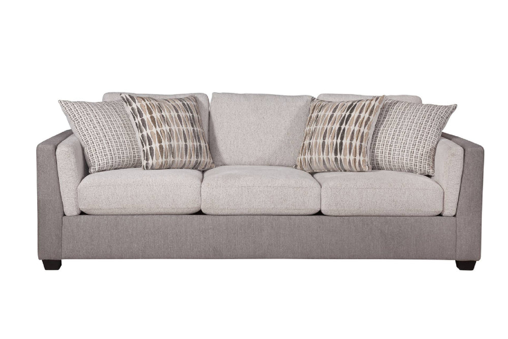 Vista frontal de sofá con acolchado crema y gris claro con cuatro cojines decorativos con patrones, todo sobre un fondo blanco. 