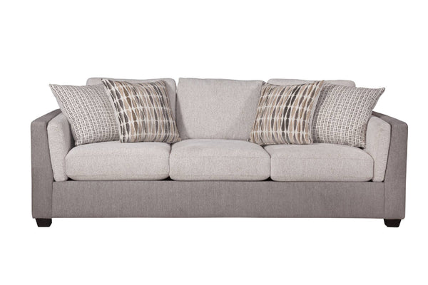 Vista frontal de sofá con acolchado crema y gris claro con cuatro cojines decorativos con patrones, todo sobre un fondo blanco. 