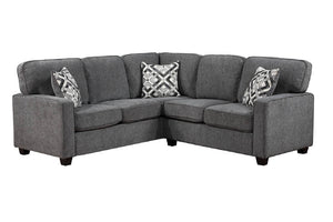 Un sofá seccional de tela gris con dos almohadas decorativas estampadas, que se muestra sobre un fondo blanco liso.