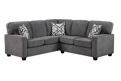 Un sofá seccional de tela gris con dos almohadas decorativas estampadas, que se muestra sobre un fondo blanco liso.