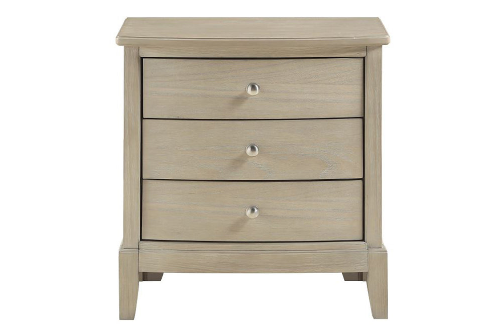 Mesa de noche hecha de madera de color crema con tres gavetas sobre un fondo blanco. 