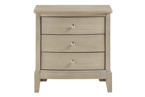 Mesa de noche hecha de madera de color crema con tres gavetas sobre un fondo blanco. 