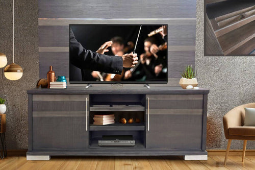 Un soporte para TV moderno de color gris con un televisor de pantalla plana montado encima, ambientado en una sala de estar contemporánea con paredes texturizadas, lámparas colgantes y una silla.