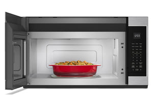 Un horno microondas de acero inoxidable y color negro, instalado sobre la estufa, con la puerta abierta, que deja ver una bandeja roja llena de comida en su interior. El microondas cuenta con un panel de control digital en el lado derecho.