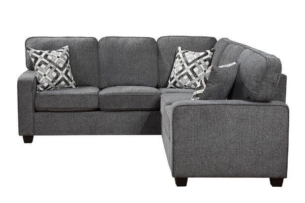 Sofá seccional de tela gris con chaise longue orientada hacia la derecha, con dos cojines decorativos estampados, que se muestra sobre un fondo blanco liso.