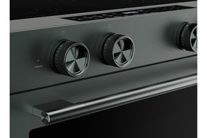 Primer plano del panel de control de un horno eléctrico moderno de color verde, con tres perillas metálicas redondas y una manija horizontal, sobre un fondo oscuro.