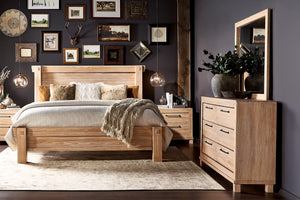 Conjunto de habitación de cama color marrón claro, un gavetero con espejo y dos mesas de noche con objetos decorativos. 