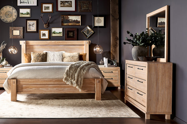 Conjunto de habitación de cama color marrón claro, un gavetero con espejo y dos mesas de noche con objetos decorativos. 