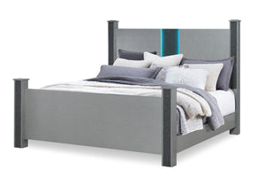 Cama gris con ropa de cama y almohadas blancas sobre un fondo blanco.