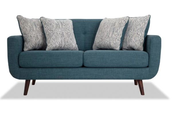 Loveseat azul con cojines estampados sobre fondo blanco