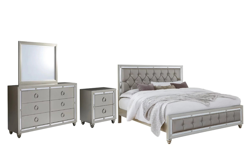 Juego de dormitorio moderno en acabado gris claro con detalles brillantes, presentado sobre fondo blanco. Incluye cama matrimonial con cabecera y pie tapizados en diseño capitoné, gavetero con seis gavetas y tiradores circulares metálicos, espejo rectangular a juego y una mesa de noche de dos gavetas. Diseño contemporáneo con líneas rectas y acabados tipo espejo en los bordes.
