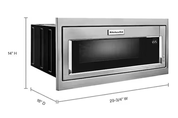 Microondas empotrable KitchenAid en acero inoxidable con pantalla digital y puerta de vidrio negro. La imagen muestra dimensiones de instalación de 29.75 pulgadas de ancho, 14 pulgadas de alto y 18 pulgadas de profundidad.